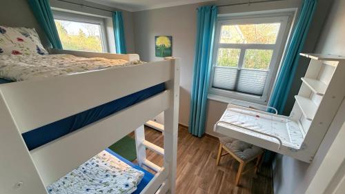 a bedroom with two bunk beds and a window at Bauernhof Claussen Fehmarn in Fehmarn