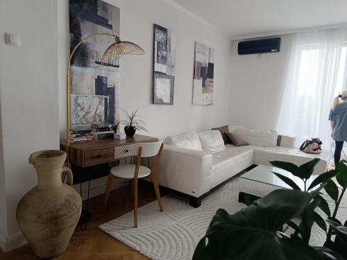 a living room with a white couch and a table at White Lounge Haustor in Podgorica