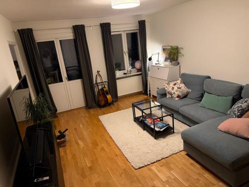a living room with a couch and a table at PRIVATE ROOM in a shared apartment in Västerås