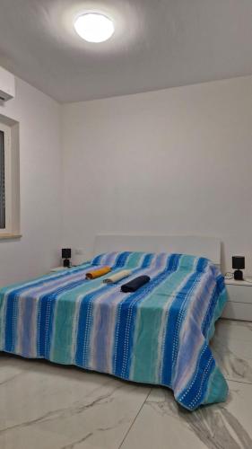 a bed in a white room with towels on it at Casa Jenny sul mare in Scalea