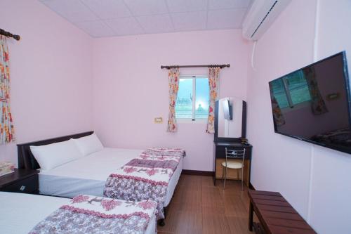 a hotel room with two beds and a flat screen tv at Du Du Hao B&B in Yongan