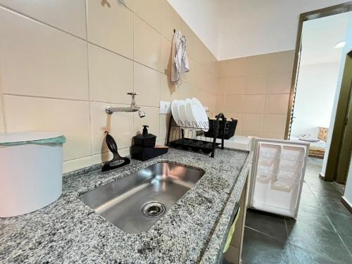 a kitchen counter with a sink in a room at Unidade 2 - GoHost Suítes in Ribeirão Preto