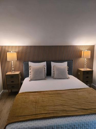 a bedroom with a large bed with two lamps at Espaço Roteiro de Mimos in São Vicente Ferreira