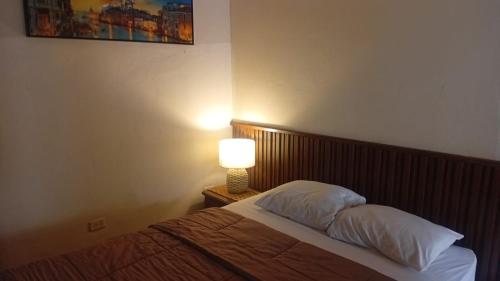 a bedroom with a bed with a lamp on a night stand at Residencial De Rosas in Santiago