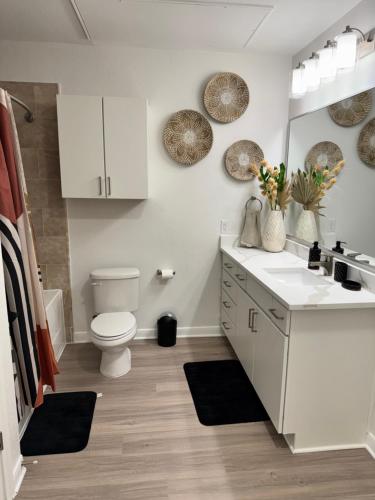 a bathroom with a toilet and a sink and a mirror at The Experience in Houston