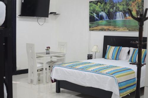 a bedroom with a bed and a table and a tv at Hotel Acropolis Callao in Lima