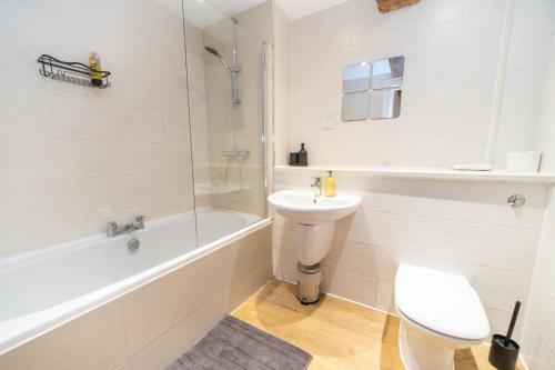 a white bathroom with a toilet and a sink at Rustic 2BR Loft Exposed Brick & Beams in Liverpool