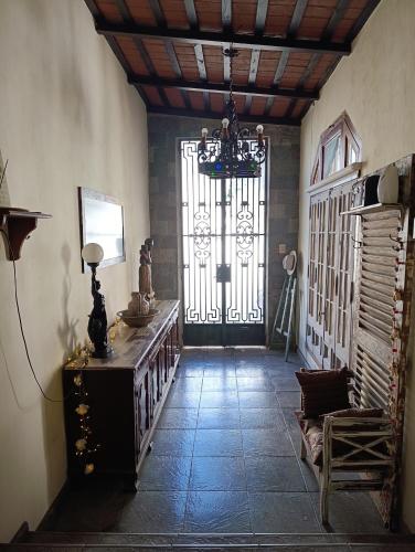 a room with a door with a chandelier and a room with a table at Casona Veroka in San Pedro