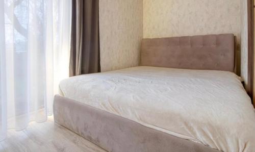 a bed in a bedroom next to a window at Bebro namai in Vilnius