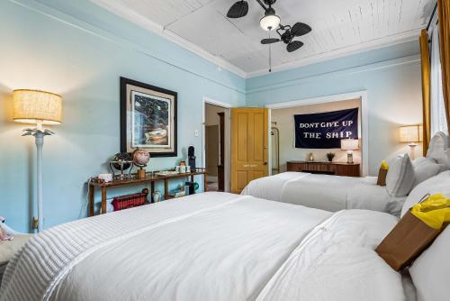 two beds in a room with blue walls at Old Carrabelle Hotel Captains Quarters Suite in Carrabelle