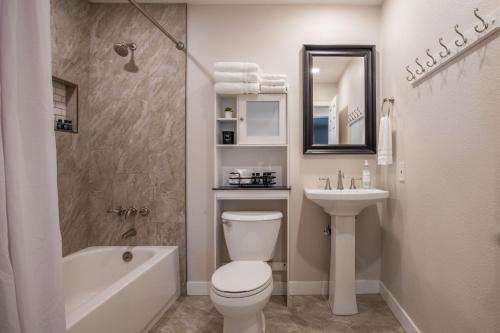 a bathroom with a toilet and a sink and a tub at Scottsdale Osborn in Scottsdale