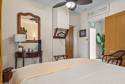 a bedroom with a bed and a mirror and a table at Old Carrabelle Hotel Regatta Room in Carrabelle