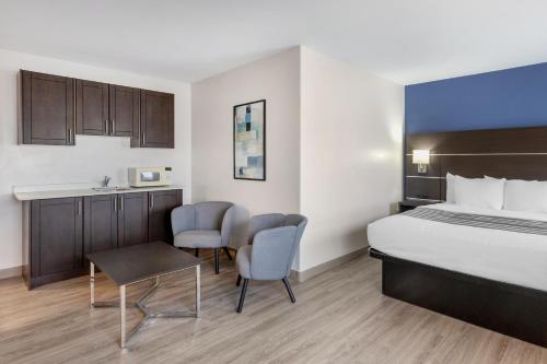 a hotel room with a bed and a table and chairs at Best Western Kincardine in Kincardine