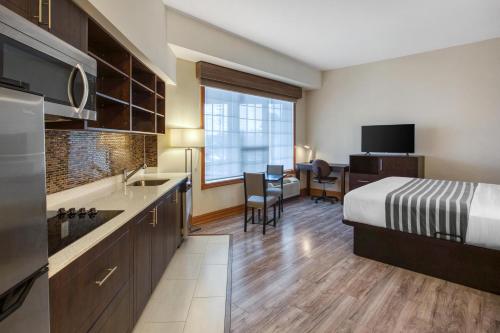 a hotel room with a bed and a kitchen at Best Western Kincardine in Kincardine