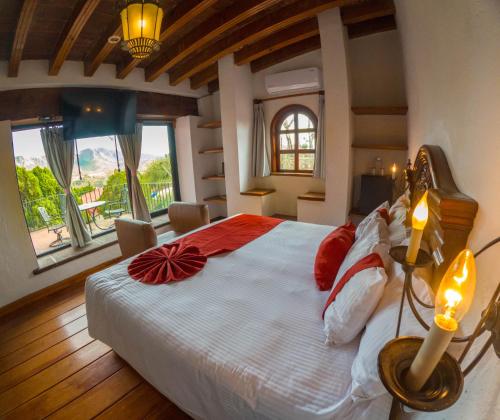 a bedroom with a large bed with red and white pillows at Misión Grand Casa Colorada in Guanajuato