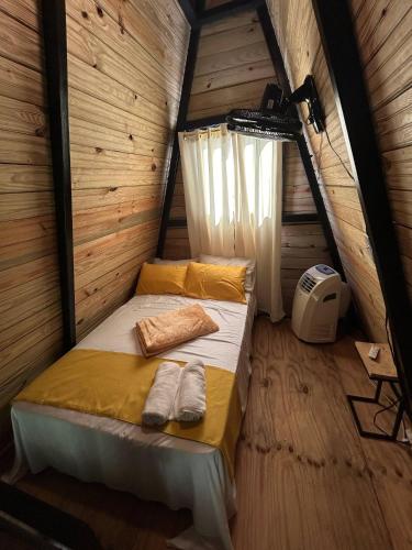 a bedroom with a bed in a wooden cabin at Alpine Cabin PR 2026 in Tavera Abajo