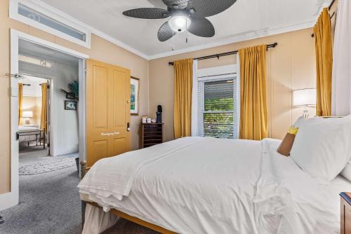 a bedroom with a bed and a ceiling fan at Old Carrabelle Hotel Hemingway Suite in Carrabelle