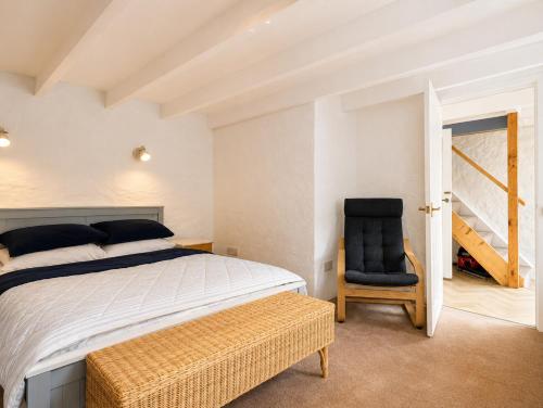 a bedroom with a bed and a chair at Holiday Cottage Falmouth in Penryn
