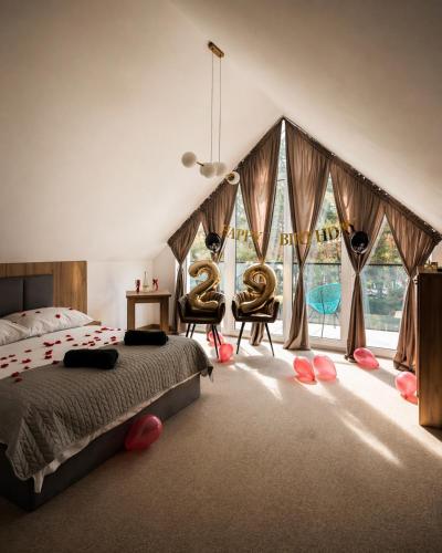 a bedroom with a large bed and large windows at Eden Apartament Jakuzzi, sauna in Rozewie