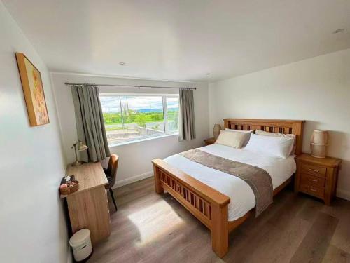a bedroom with a large bed and a window at Trelawney in Coleraine