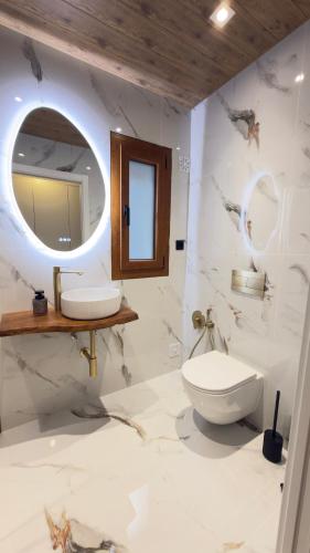 a bathroom with a toilet and a sink and a mirror at River Breeze Douro - Casa Touriga in Marmelal