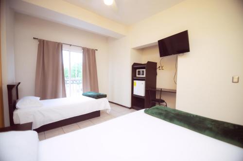 ein Zimmer mit zwei Betten und einem Fernseher in der Unterkunft Nova Departamentos in Cadereyta Jiménez