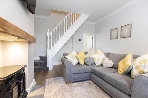 a living room with a gray couch and stairs at High Lands in Cockfield