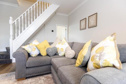 a living room with a gray couch with yellow pillows at High Lands in Cockfield