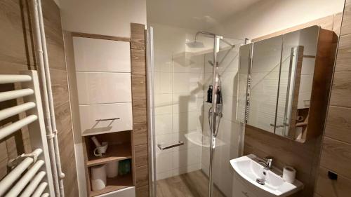 a bathroom with a glass shower and a sink at Rondel in Žilina
