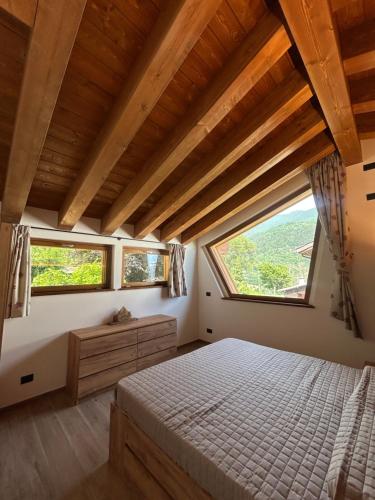 a bedroom with a bed and a large window at LA CASETTA - Appartamento CERVINO in Torgnon