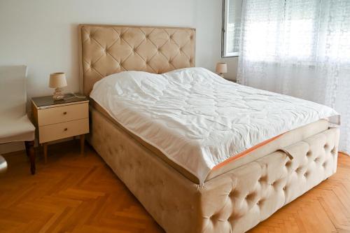 a large bed in a bedroom with a window at Apartmani Andjelka in Tivat