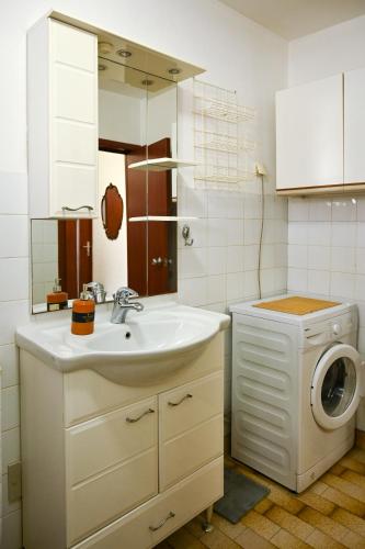 a bathroom with a sink and a washing machine at Apartmani Andjelka in Tivat