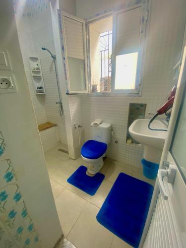 a bathroom with a blue toilet and a sink at Dar El Mdina in Mahdia