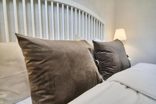 a bed with gray pillows and a head board at Smart apartmány Prešov in Prešov