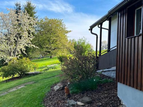 a garden next to a house with a yard at Chalupa Lindenberg in Jestrabi V Krkonosich