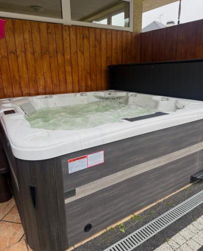 a jacuzzi tub in a room with a wooden wall at Willa Marion in Karpacz