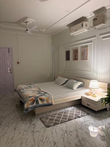 a bedroom with a bed and a table with a lamp at Aashiyana retreat in Duimukh