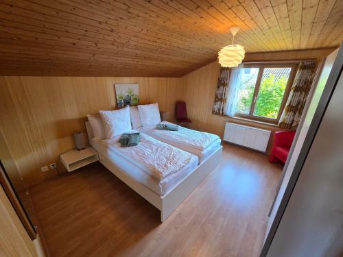 a bedroom with a large bed and a window at Swiss Chalet direkt am Thunersee in Thun