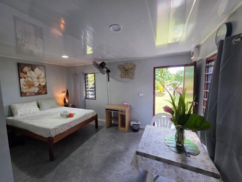 a bedroom with a bed and a table and a window at G&A Friendly stay in Port Vila