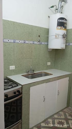 a kitchen with a sink and a stove at Hospedaje "Doña Tomasa" -A 15 minutos del aeropuerto -Parking in Ezeiza