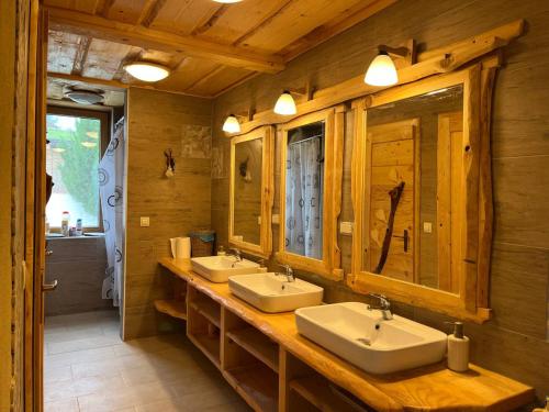 a bathroom with two sinks in a log cabin at Tree house - Ethno holistic village Apače in Apače