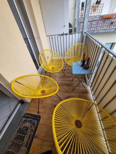 a group of yellow tables and chairs on a balcony at Apartement Elsterblick in Gera