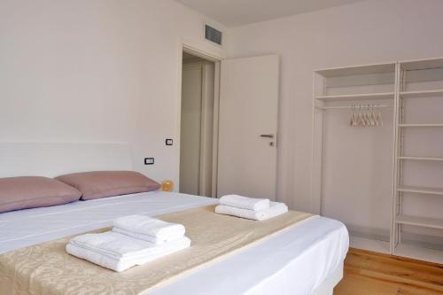 a white bed with two folded towels on it at Le Mele - Alle 5 Torri in Mezzolombardo