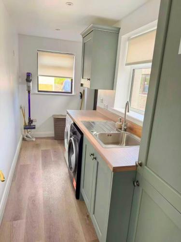 a kitchen with a sink and a washing machine at Trelawney in Coleraine