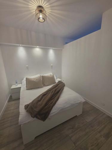 a bedroom with a bed with a blanket on it at Apartament Anny 1 in Grodzisk Mazowiecki