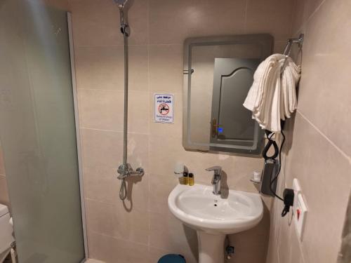 a small bathroom with a sink and a mirror at Hotel Lujain Al Dhahabi Star in Al ‘Awālī