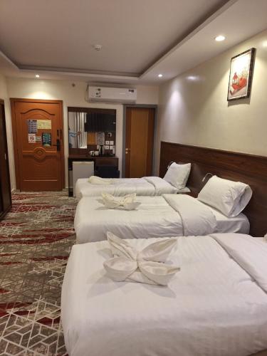 a hotel room with four beds with bows on them at Hotel Lujain Al Dhahabi Star in Al ‘Awālī