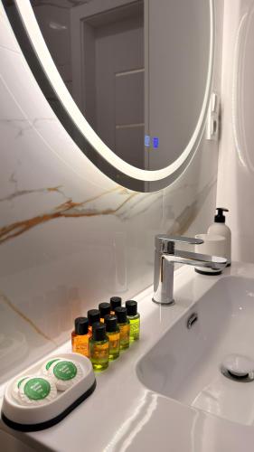 a bathroom sink with bottles of essential oils on it at Brickstone Apartments Malbork in Malbork