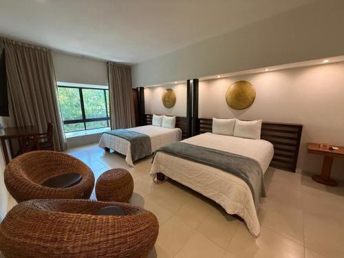 pokój hotelowy z dwoma łóżkami i kanapą w obiekcie Cuatro Lunas Hotel Boutique w mieście Palenque
