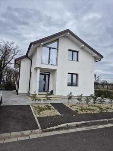 a white house with black windows at MarioLia Comfort Residence in Oradea